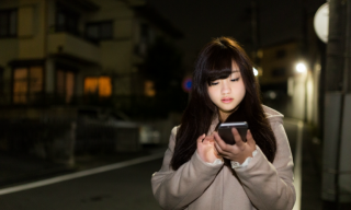 夜道でiPhoneを使っている女の子