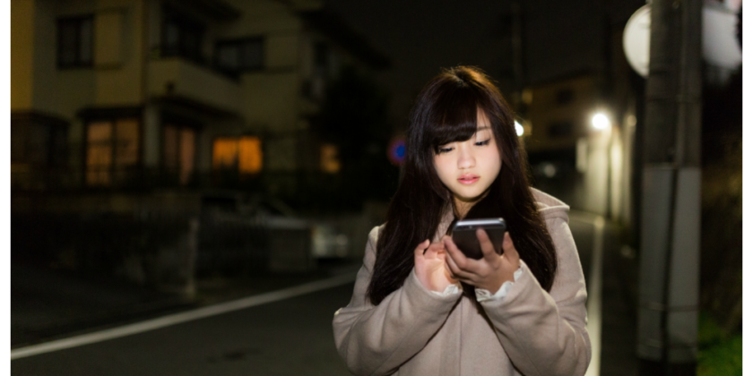夜道でiPhoneを使っている女の子
